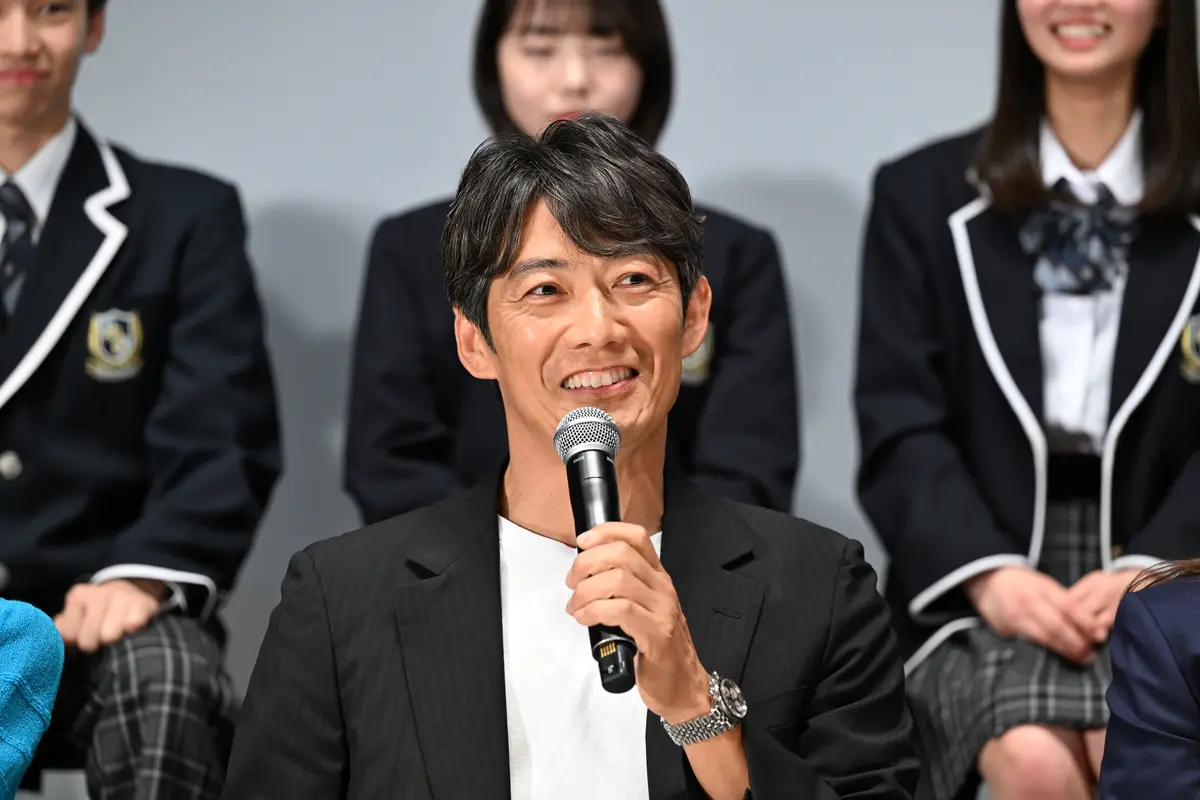 壇上で生徒の質問に答える反町隆史