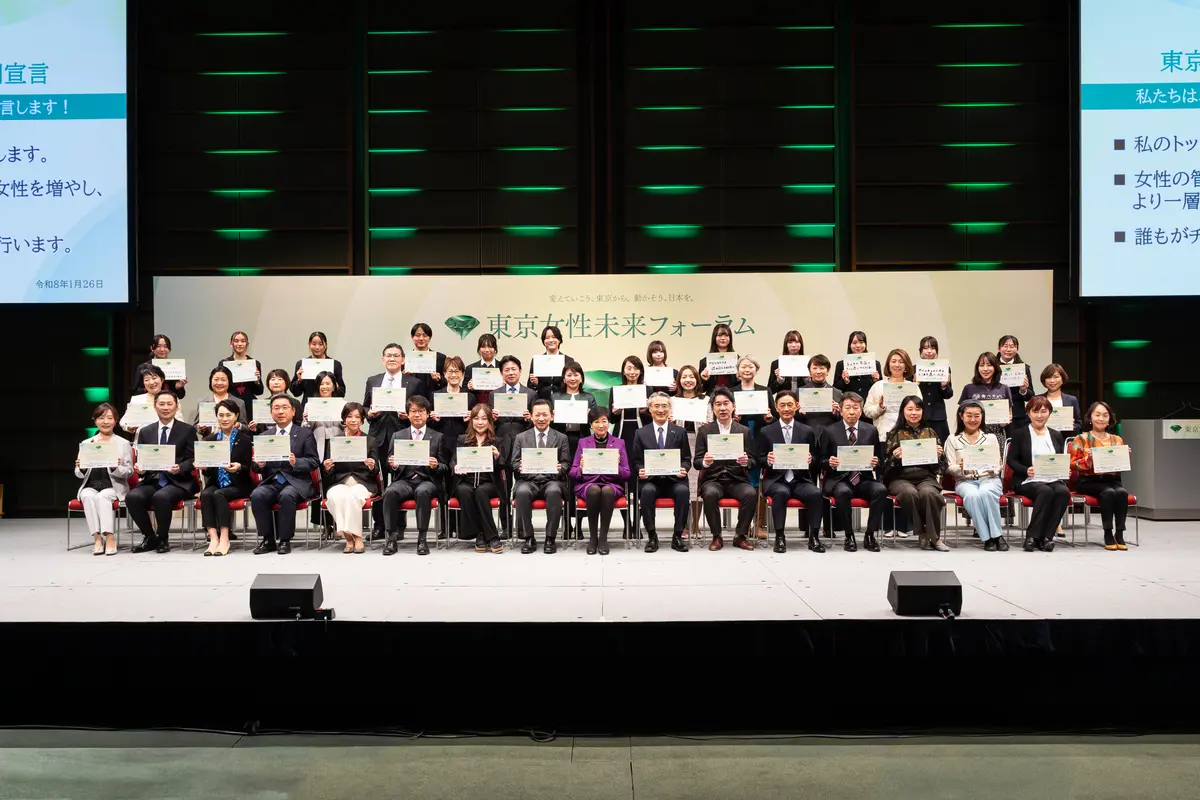 「東京女性未来フォーラム2026」で、小池百合子都知事を囲んで記念撮影に応じる「女性経営者アワード」受賞者や登壇した中高生らによる記念撮影