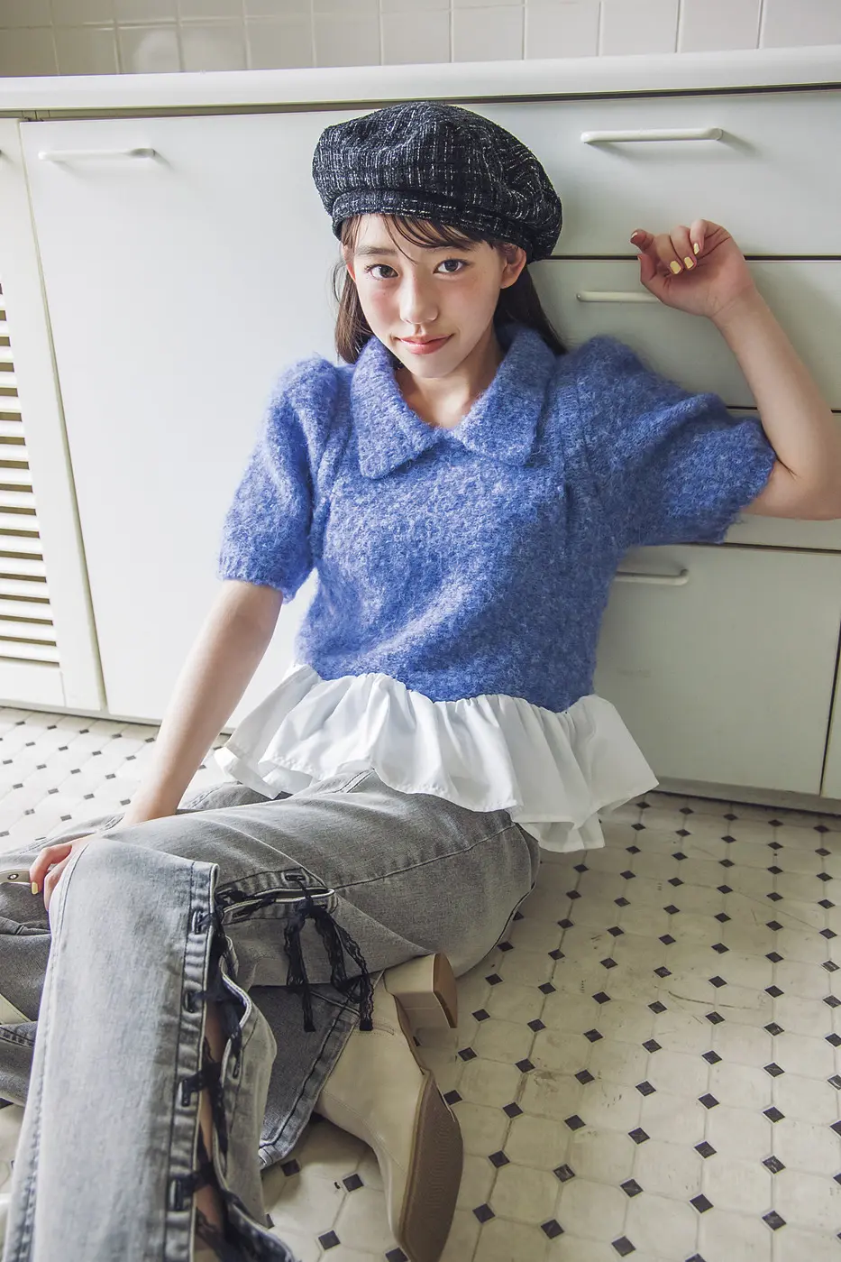 トレンドのペプラムニットを着た岡本望来さん