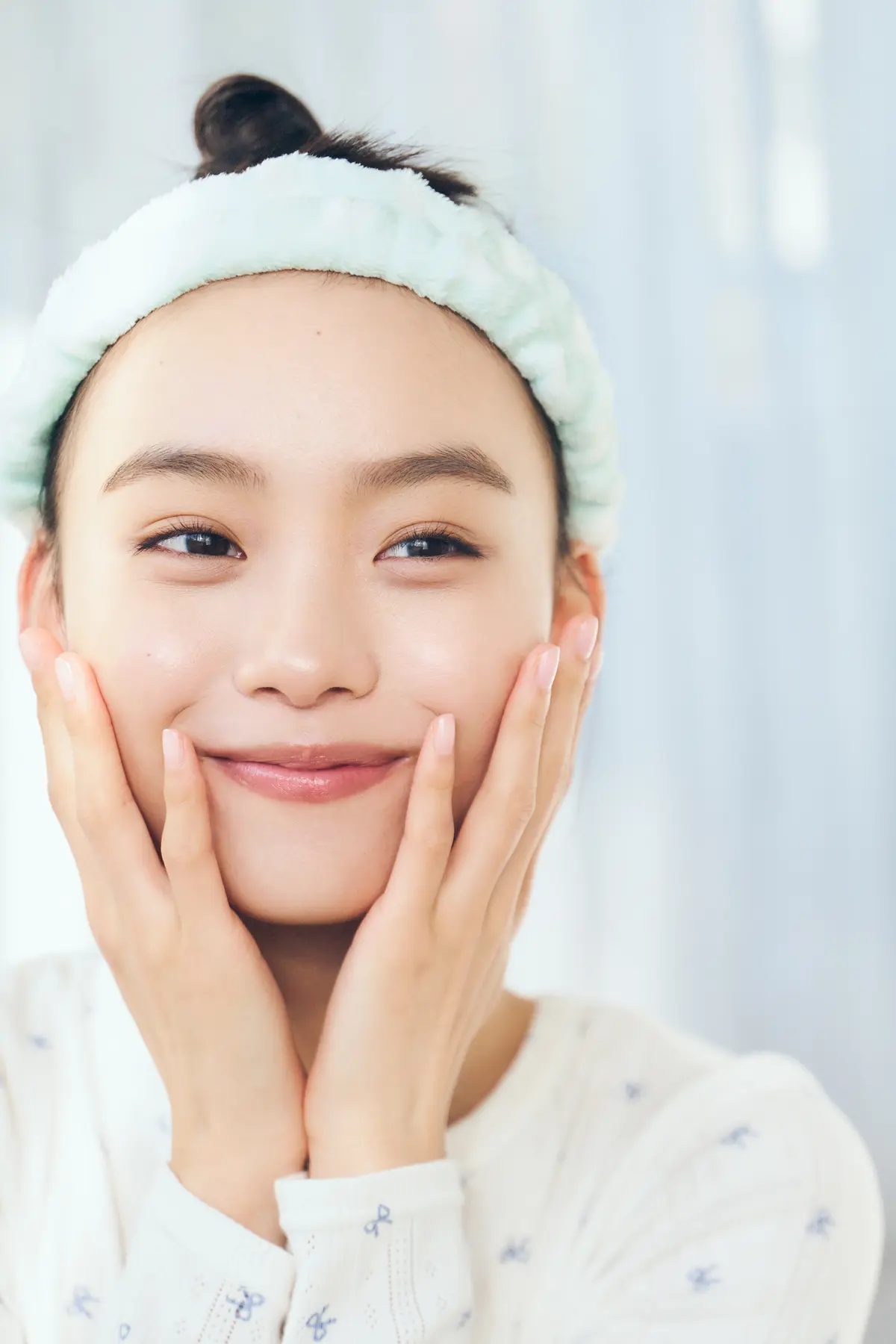 顔に塗った化粧水を手のひらで押し込む様子